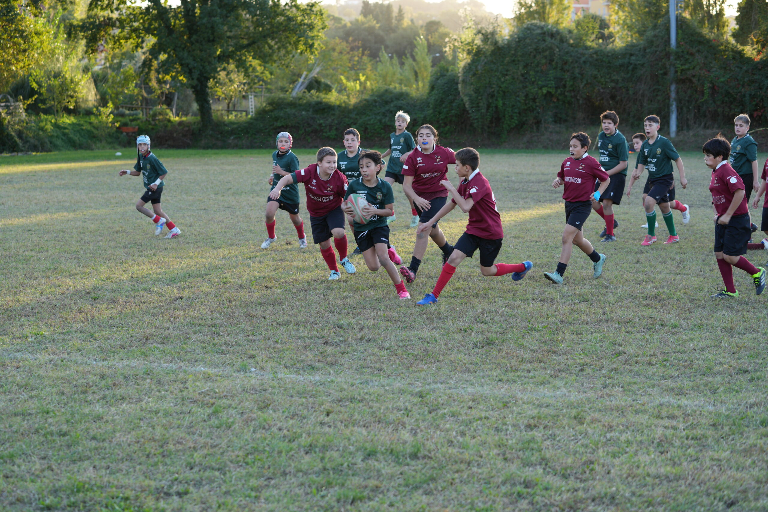 Un giocatore della Ternana Rugby in maglia verde corre con il pallone durante il raggruppamento Under 12